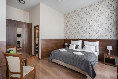 a bedroom with a bed and a table with a chair at Elit Boutique Rooms- Best Location by BQA in Budapest