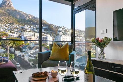 a living room with a table with two glasses of wine at Latitude Aparthotel by Totalstay in Cape Town