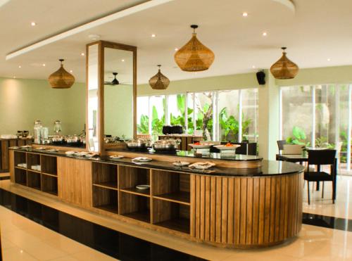 a restaurant with a bar in the middle of a room at Crystalkuta Hotel - Bali in Kuta