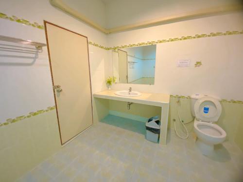 a bathroom with a toilet and a sink and a mirror at โชติอนุสรณ์ รีสอร์ท ชุมพร in Ban Bang Mak (1)