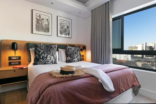 a bedroom with a bed with a large window at Latitude Aparthotel by Totalstay in Cape Town