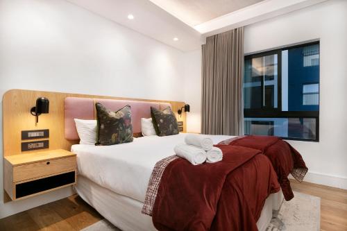 a hotel room with a bed with towels on it at Latitude Aparthotel by Totalstay in Cape Town