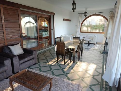 uma sala de estar com um sofá, uma mesa e cadeiras em Villa meublée face à la mer, Golf et Verdure em El Jadida