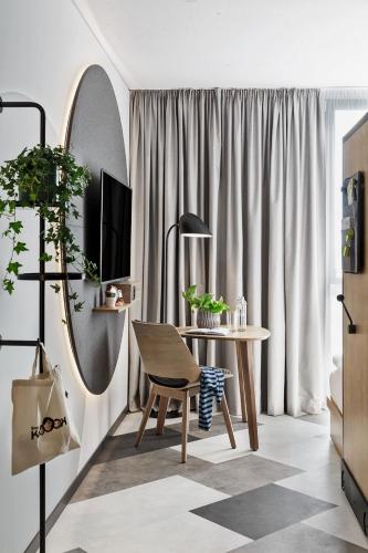 a living room with a table and a mirror at Stay KooooK Bern Wankdorf - Online Check In in Bern
