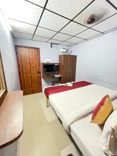 1 dormitorio con 1 cama grande y TV en Skyry Hotel Iyyapanthangal en Chennai
