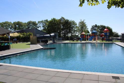 - une piscine dans un parc avec une aire de jeux dans l'établissement Chalet Familienzeit, à Lathum