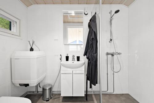 y baño blanco con lavabo y ducha. en Northern Light cottage 1, 