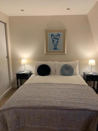 a bedroom with a large bed with two lamps at The Riding Gate Apartment in Kent