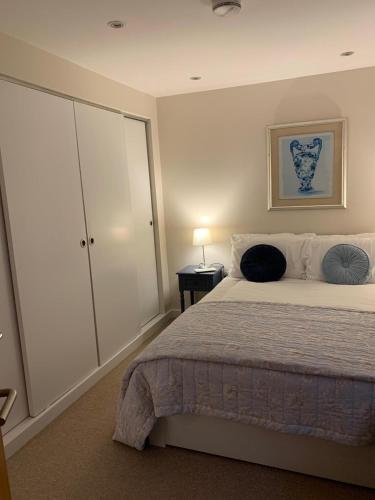 a bedroom with a large bed and a cabinet at The Riding Gate Apartment in Kent