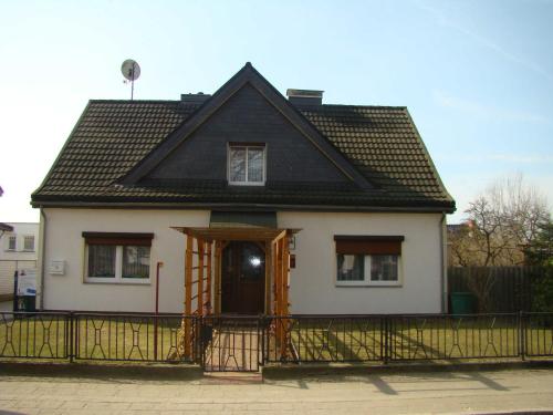 een klein wit huis met een zwart dak bij Ferienwohnungen Segebrecht Ahlbeck in Ahlbeck