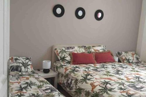 a bedroom with a bed and two o clocks on the wall at La petite maison in Bobigny