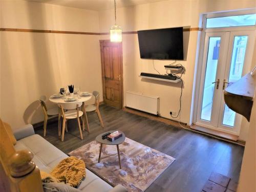 sala de estar con sofá, mesa y TV en Nice 4-bedroom vacation home with indoor fireplace en Wellington