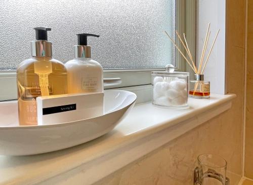 a bathroom counter with two bottles of soap and a mirror at Glen Nevis Holidays in Fort William