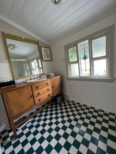 bagno con lavandino, specchio e pavimento a scacchi di Private suite in an Historic 1865 Homestead a Dubbo