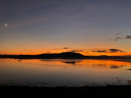 a sunset over a body of water at Culag Lochside Self Catering in Luss