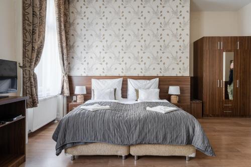 a bedroom with a bed and a wall with a wallpaper at Elit Boutique Rooms- Best Location by BQA in Budapest