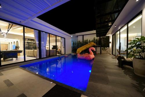 uma piscina com escorrega numa casa em Movenpick Pool villa by Angkana em Na Jomtien