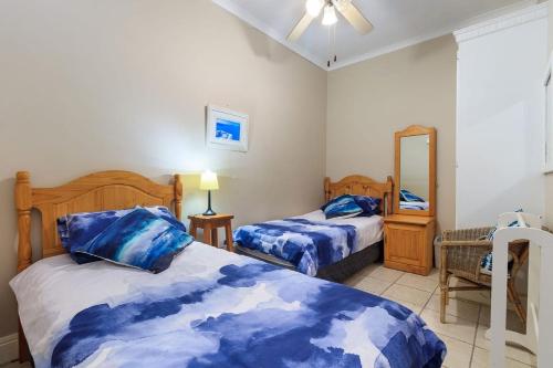 Unit 18 Kei Sands Resort في Kei Mouth: غرفة نوم بسريرين ومرآة