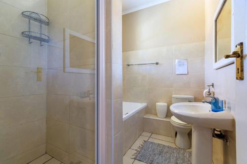 a bathroom with a shower and a sink and a toilet at Unit 18 Kei Sands Resort in Kei-mouth Village