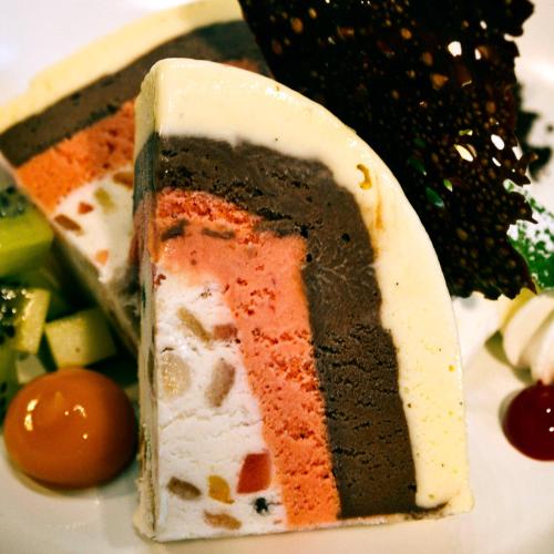 a piece of cake on a plate with vegetables at Guggital Hotel Restaurant in Zug