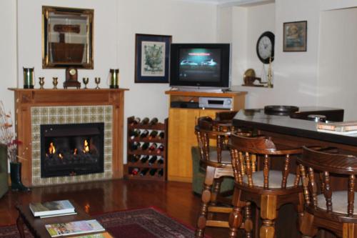 a living room with a fireplace and a television at Knysna Manor House in Knysna