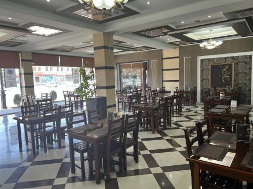 ブハラにあるGrand Shirin Palace Buxの木製テーブルと椅子が備わるレストラン