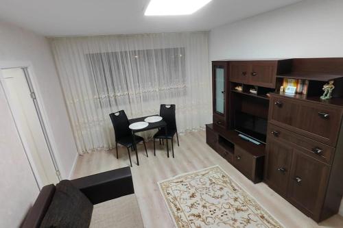 a living room with a table and chairs and a cabinet at Apartament în Buzău in Buzau