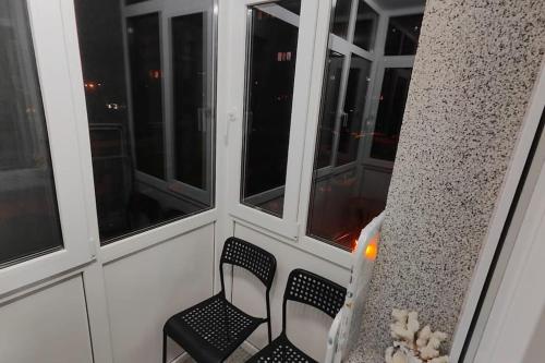 a balcony with two chairs and two windows at Apartament în Buzău in Buzau