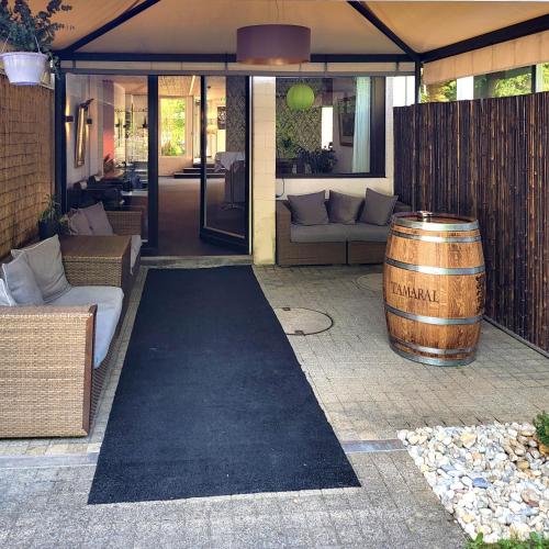 a patio with a barrel sitting next to a house at Guggital Hotel Restaurant in Zug