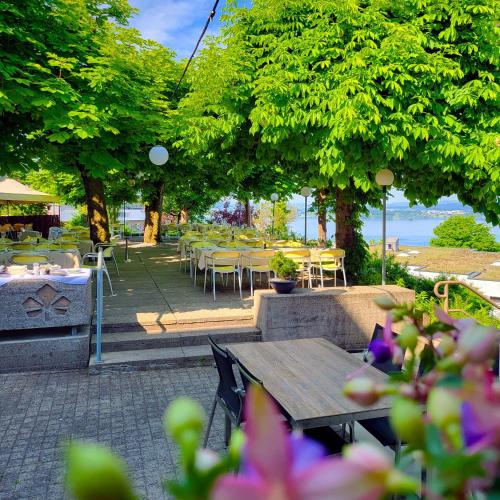 an outdoor patio with tables and chairs and trees at Guggital Hotel Restaurant in Zug