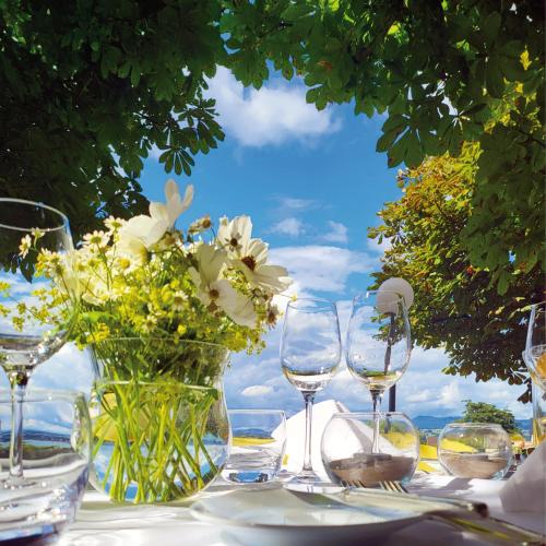 a table with wine glasses and a vase of flowers at Guggital Hotel Restaurant in Zug