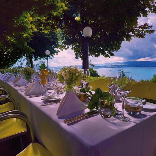 einen Tisch mit einem weißen Tischtuch und Weingläsern in der Unterkunft Guggital Hotel Restaurant in Zug