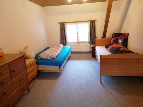 - une chambre avec un lit, un canapé et une fenêtre dans l'établissement Schwellbrunn,Ferienwohnung mit Säntissicht, à Schwellbrunn