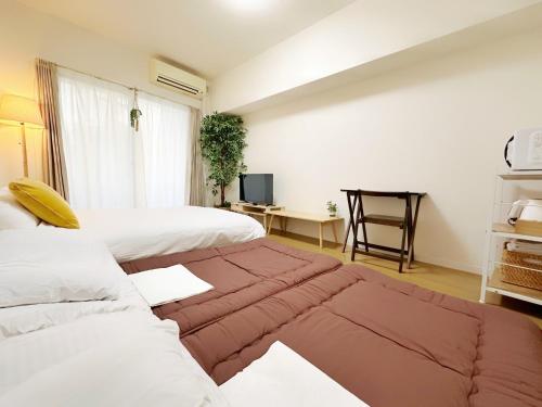 una camera d'albergo con due letti e un divano di Picoro Hakata - Vacation STAY 11322 a Fukuoka