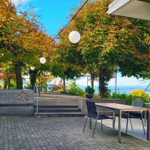 a table and chairs in a park with trees at Guggital Hotel Restaurant in Zug