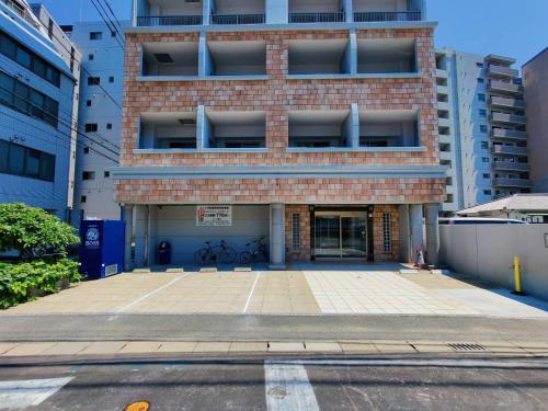 un parcheggio vuoto di fronte a un edificio di mattoni di Picoro Hakata - Vacation STAY 11322 a Fukuoka