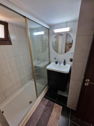 uma casa de banho com um lavatório, um chuveiro e um espelho. em The Belvedere Villa Latchi em Lachi
