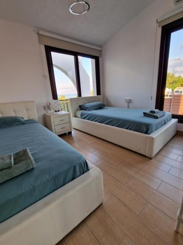 duas camas num quarto com duas janelas em The Belvedere Villa Latchi em Lachi