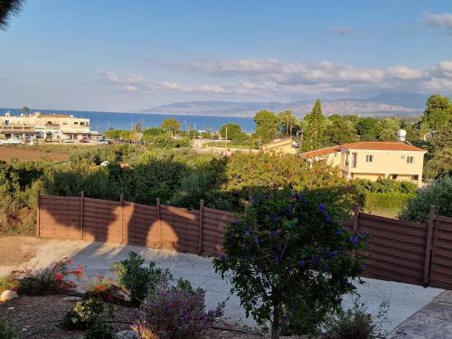 a fence in a garden with a view of the ocean at The Belvedere Villa Latchi in Lachi