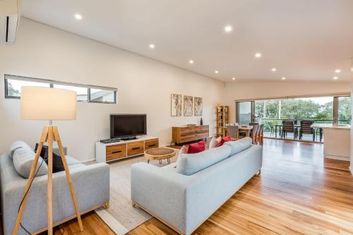 a living room with a couch and a tv at Driftwood Retreat in Quindalup