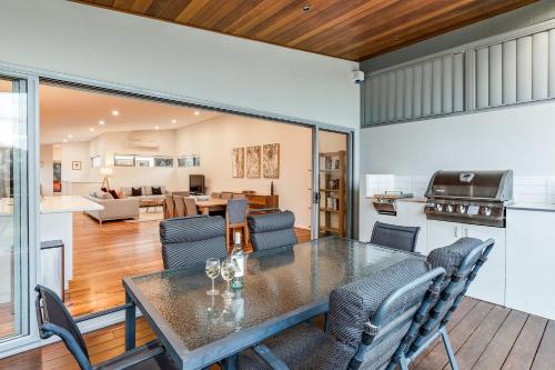 a kitchen and living room with a table and chairs at Driftwood Retreat in Quindalup