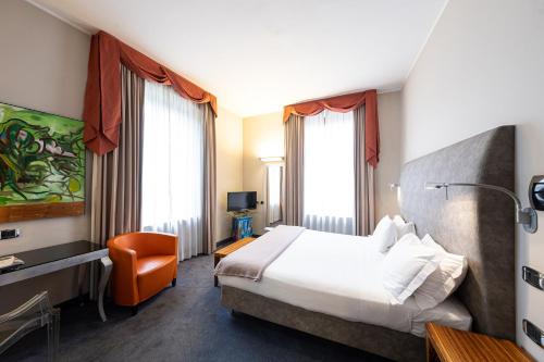 a hotel room with a bed and a chair at Settecento Hotel in Presezzo
