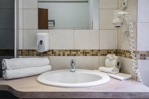 a bathroom with a sink and a mirror and towels at Elit Boutique Rooms- Best Location by BQA in Budapest