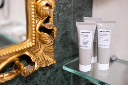 a mirror and two tubes of sunscreen on a glass table at Settecento Hotel in Presezzo