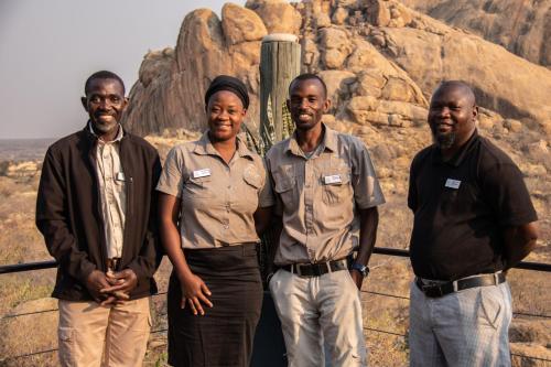 a group of men standing in front of a mountain at Ondudu Safari Lodge in Omaruru