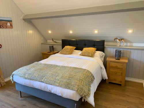 a bedroom with a large bed and two night stands at The Longhouse, Brecon Beacons (King & Twin) in Brecon