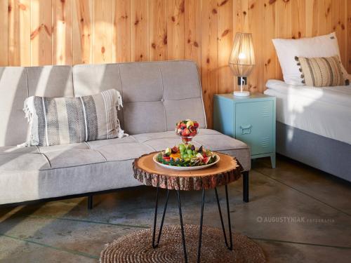 a living room with a couch and a table with a bowl of fruit at Salio Equisport Resort in Stryków