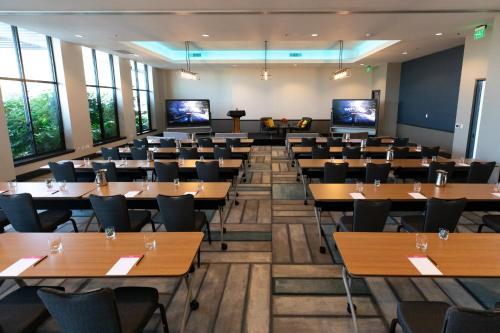 a large room with tables and chairs and windows at Hotel Indigo Seattle Everett Waterfront Place by IHG in Everett