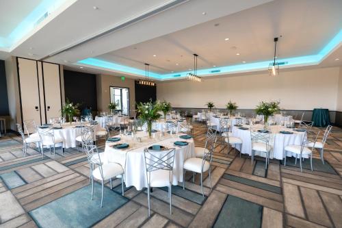 a banquet hall with white tables and chairs at Hotel Indigo Seattle Everett Waterfront Place by IHG in Everett