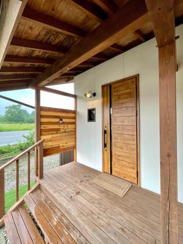 a porch of a cabin with a wooden door at Nasu YUU - 那須 悠- in Nasu-yumoto